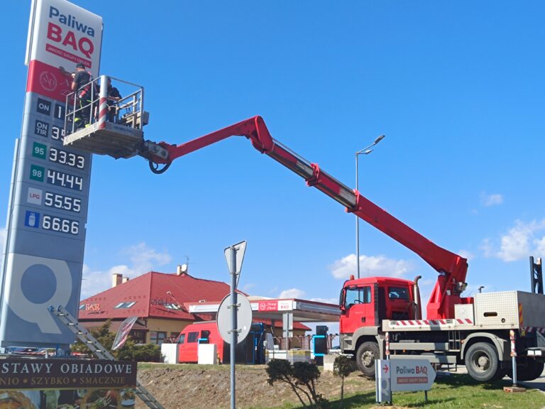 Podnośnik koszowy (zwyżka) o zasięgu 18m montuje pylon na stacji paliw w Wilczej k. Rzeszowa – wynajem wyspecjalizowanego sprzętu od NaWysoko. Praca na skarpie z zachowaniem pełnego bezpieczeństwa.